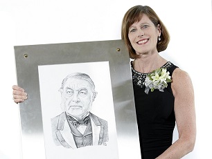 CMA President Cindy Forbes, MD holding framed portrait of Sir Charles Tupper.